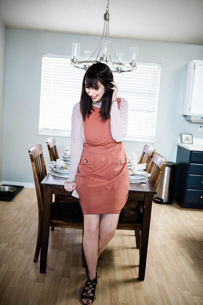 Thanksgiving Day Outfit Idea, featuring rust orange jumper dress, striped mocked turtleneck. This modest outfit is perfect for hosting a holiday dinner and features trendy boutique pieces from My Sister's Closet Boutique. // Hey There, Chelsie